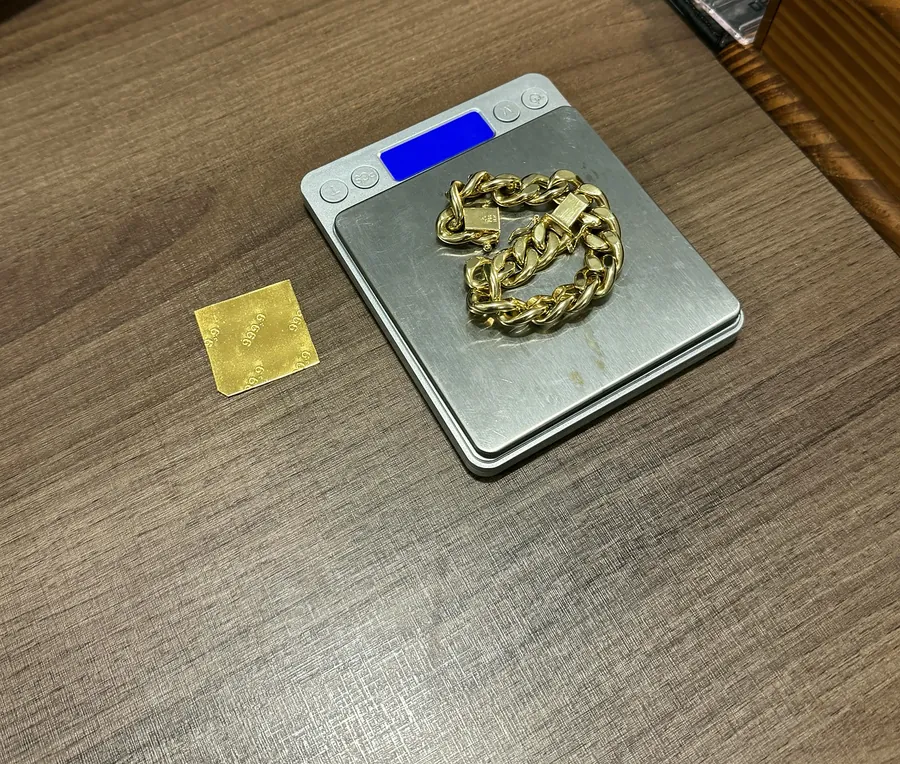 Barrinha de ouro 999,9 ao lado de pulseira de ouro na balança de precisão da TH Joias
