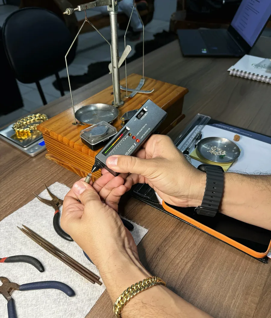 Teste de diamante e balança de pratos na mesa de avaliação da TH Joias